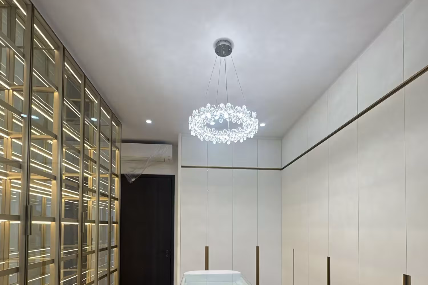 luxury walk-in wardrobe with illuminated display shelving, full-height custom cabinets, and central storage island by T7Seven Singapore